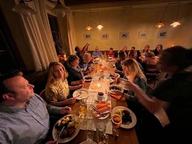 Abendliche Tafel im Gastraum der Hochsteinbaude – Gesellschaft beim Essen
