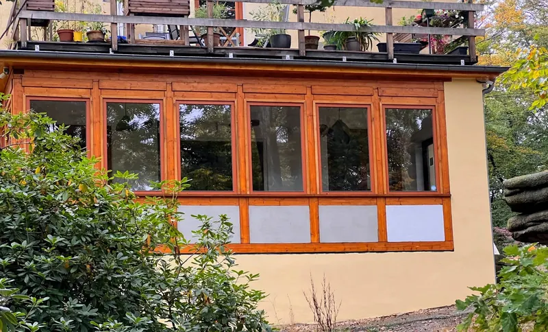 Der Anbau von außen – Holzfensterfront an der Südseite des Saals