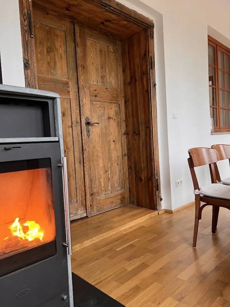 Kaminofen mit Feuer und alte Holztür im Kaminzimmer