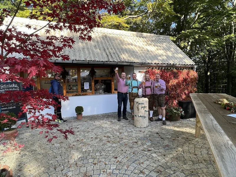 Kiosk im Herbst mit Gästen in Lederhosen am Nagelbock