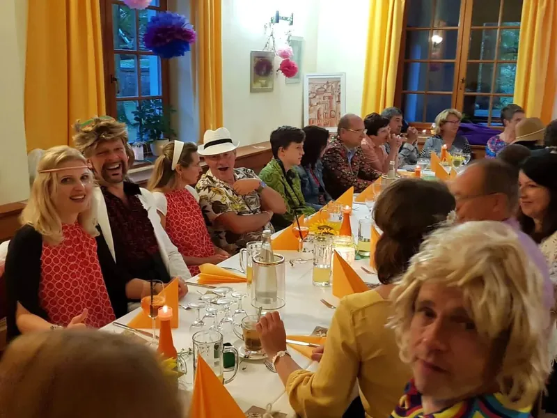 Bal przebierańców w sali gospody Hochsteinbaude – goście w kostiumach przy długim stole